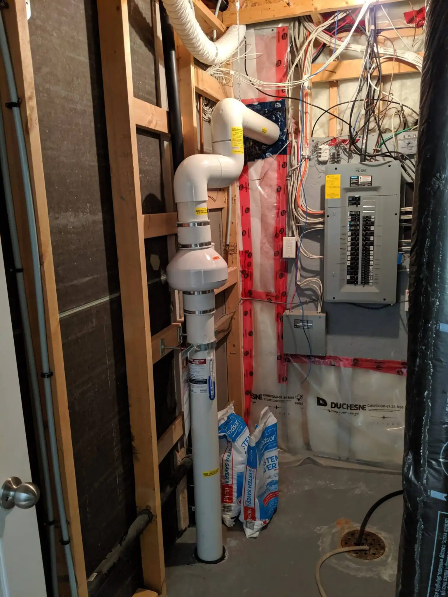 A Radon Fan And Labelled Radon Pipe Installed By Radoncare In A Basement Utility Room