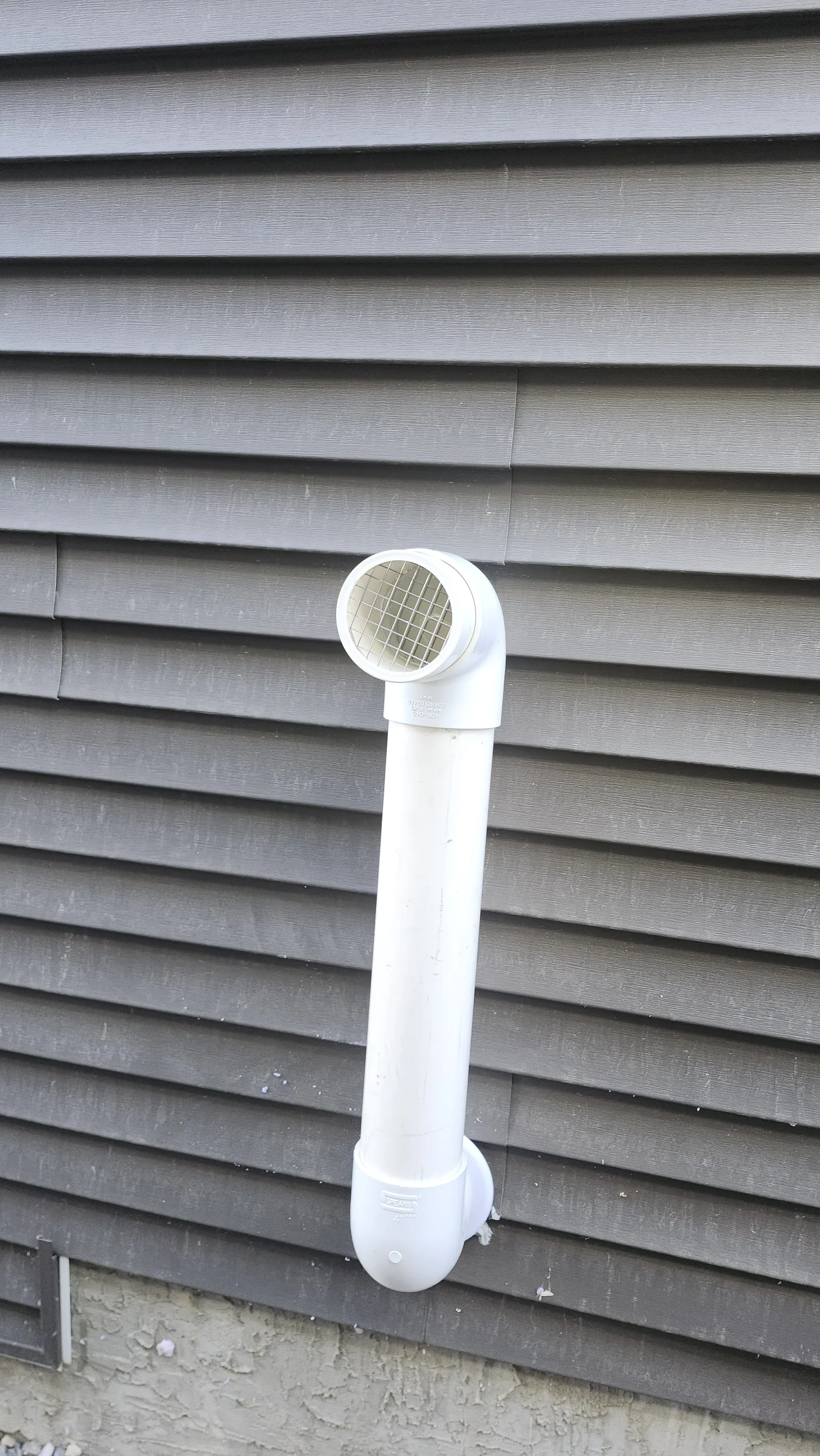 White Radon Discharge Pipe On Dark Vinyl Siding In Southwest Airdrie