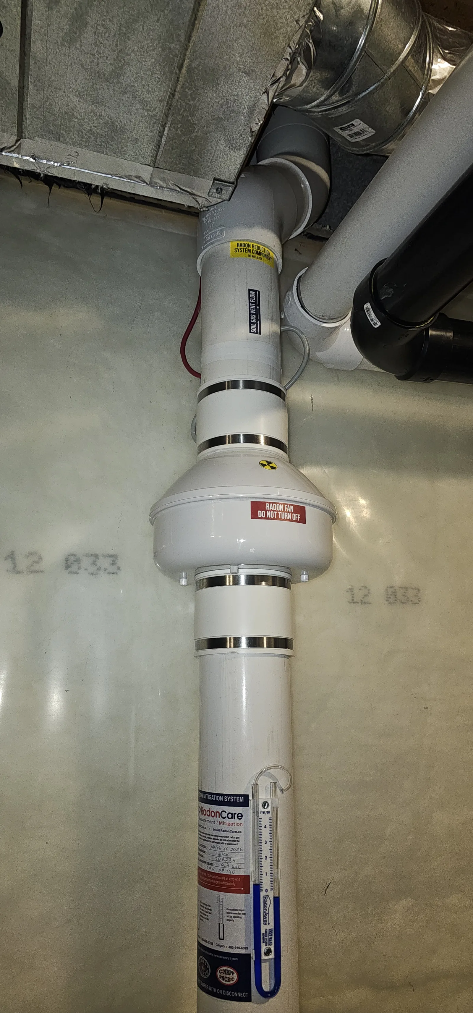 Radon Fan And Pressure Gauge On The Pipe In An Unfinished Basement Near Airdrie