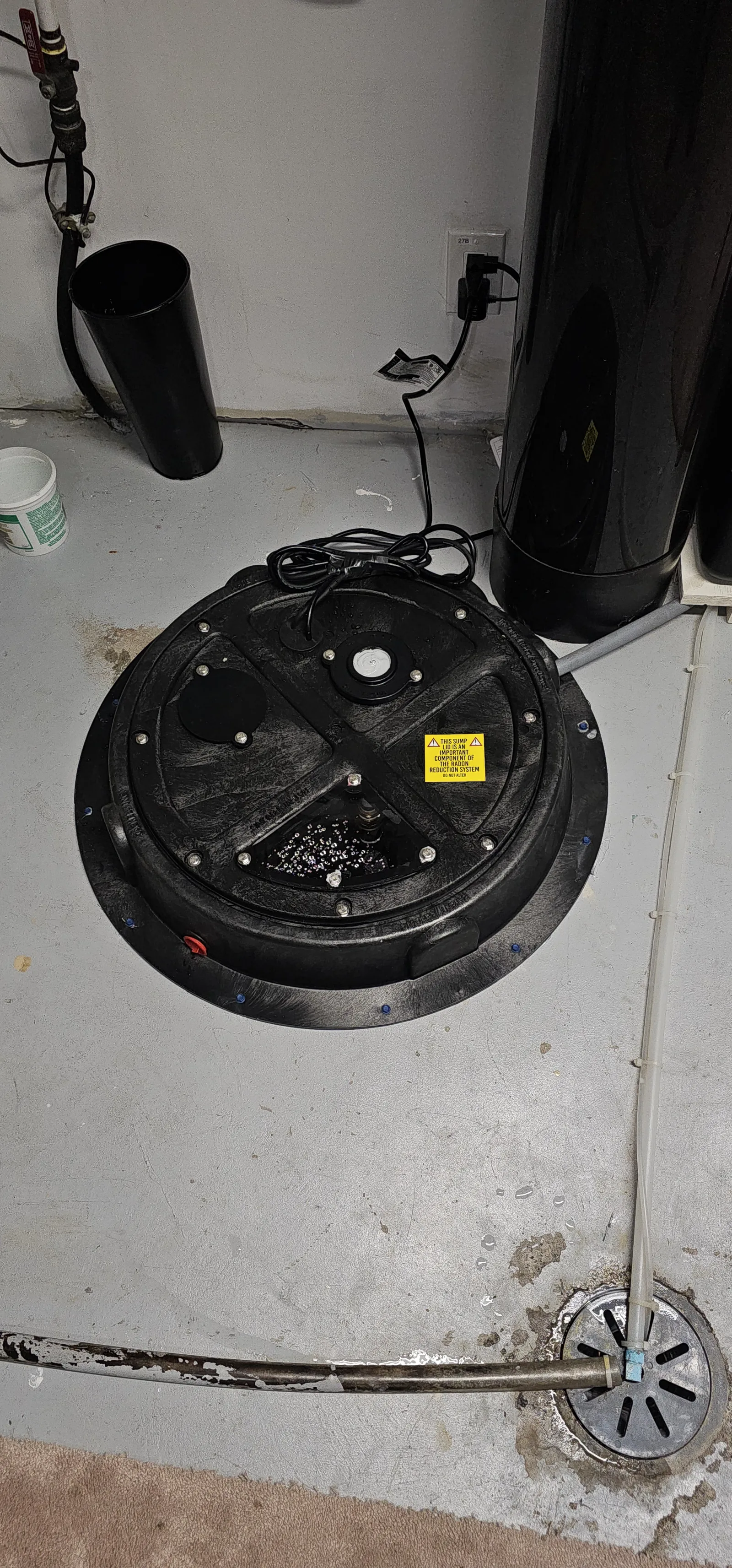 Black Sealed Sump Lid With A Radon Label On A Finished Basement Floor In Cochrane