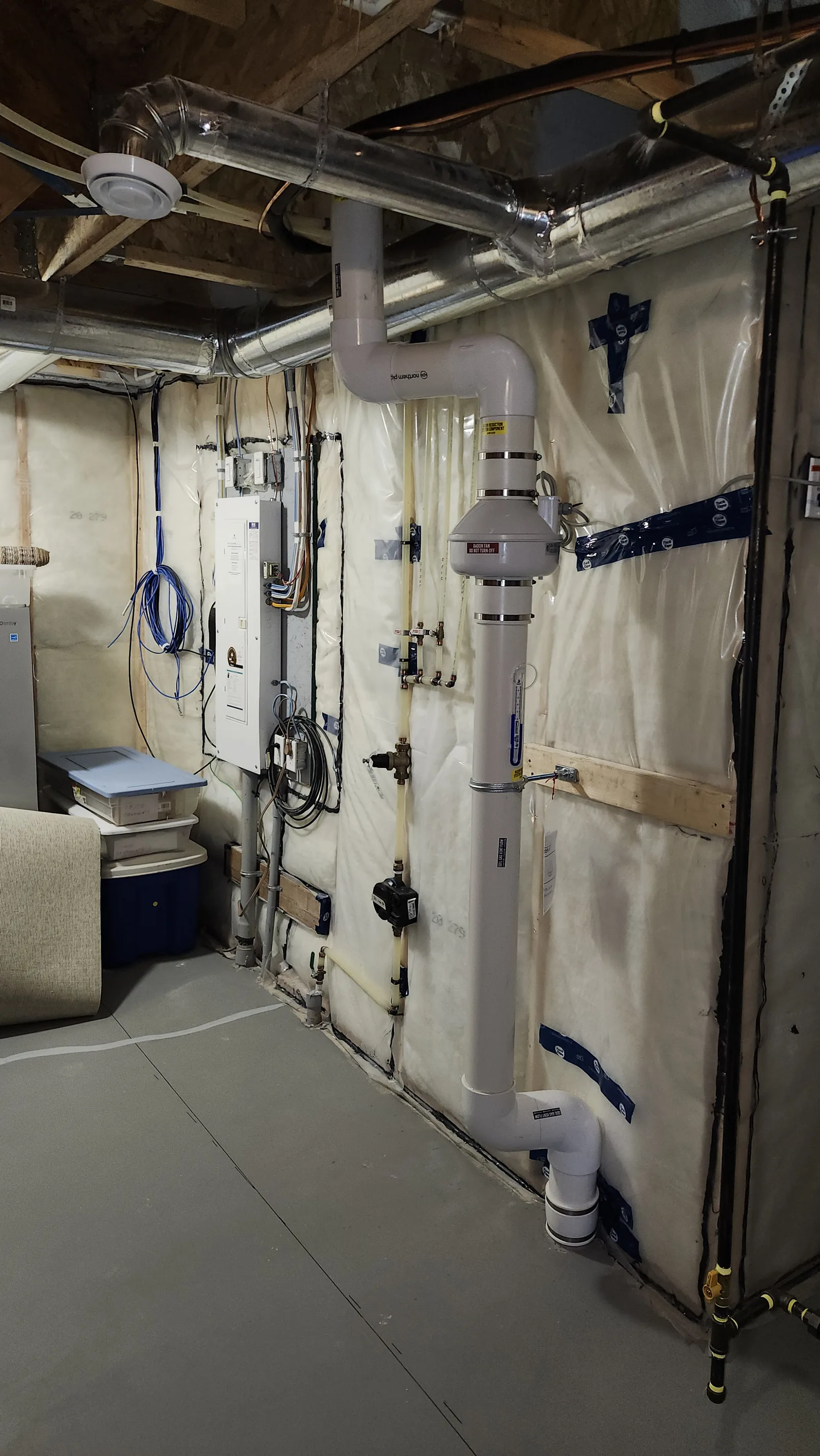 Radon Pipe And Fan Along An Unfinished Basement Wall In A Crossfield Home