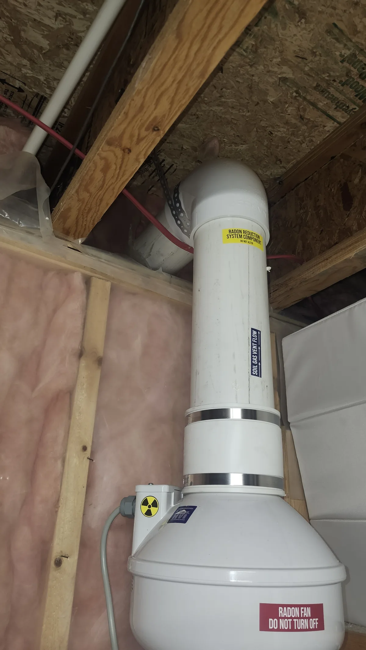 Radon Fan And Pipe Between The Basement Joists Of An Okotoks Home