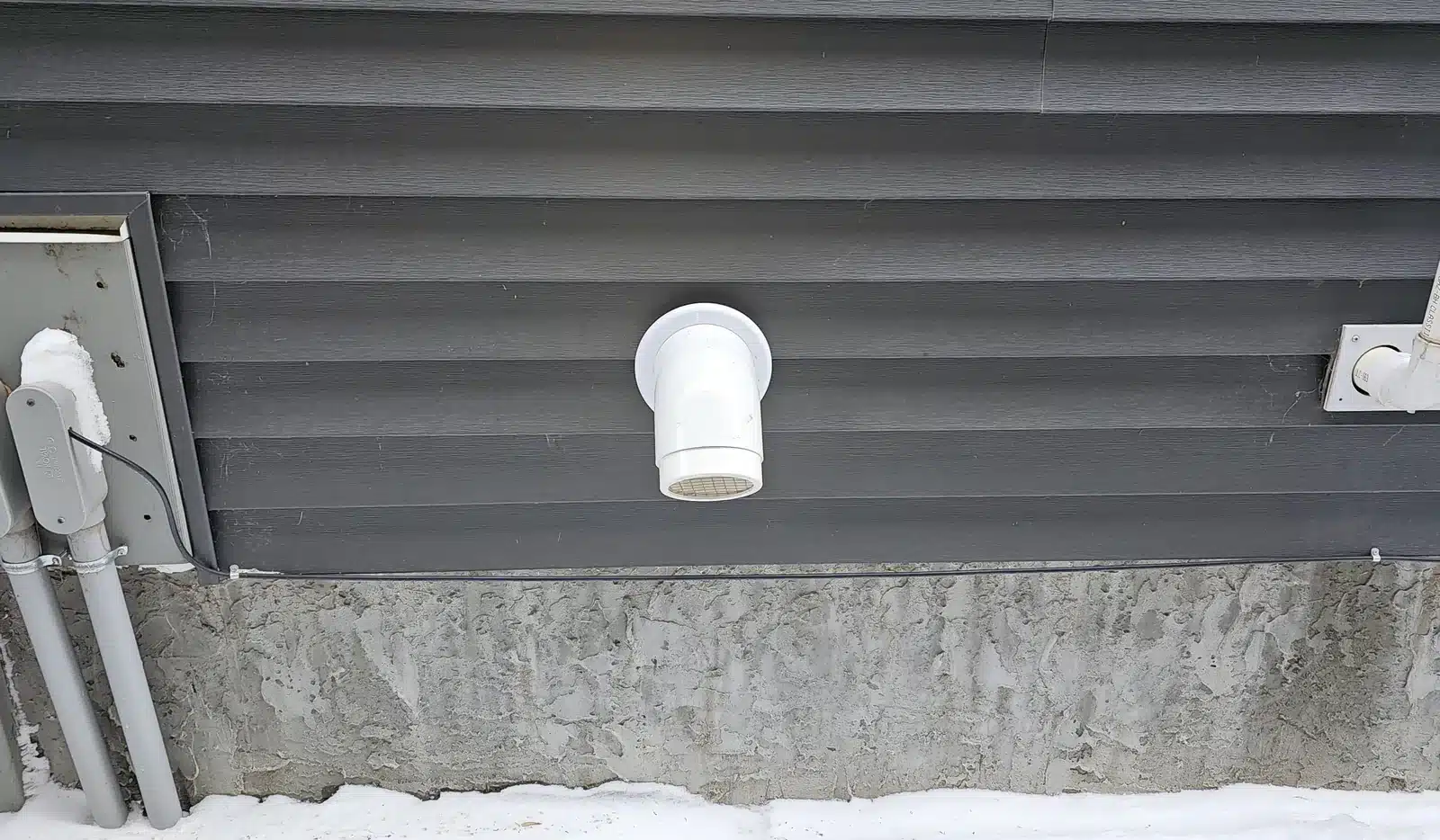 A Radon Pipe Venting Out Through The Side Wall Of A Home In Southwest Edmonton, With Snow On The Ground