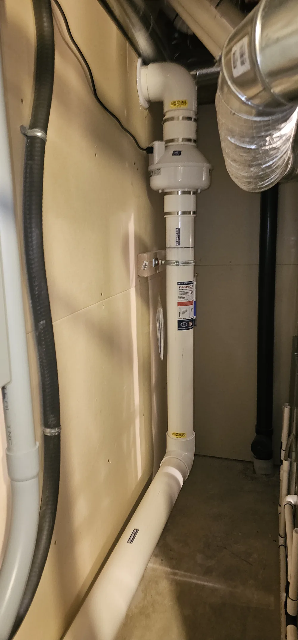 A Radon Fan And Pipe On A Mechanical Room Wall Above A Sealed Sump In A Red Deer County Home