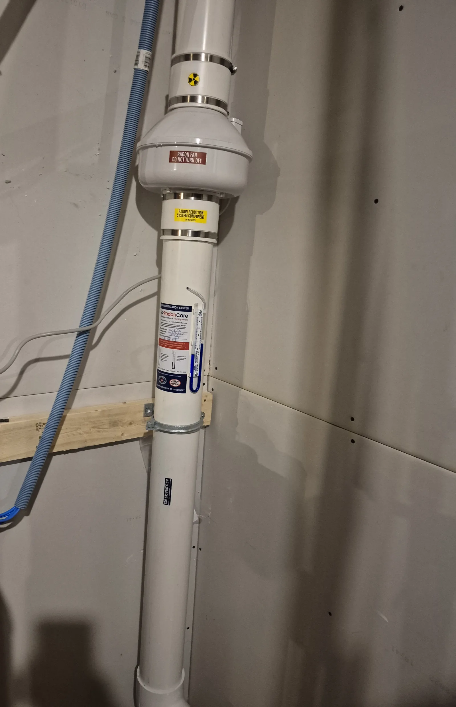 A Radon Fan, Labelled Pipe And Pressure Gauge In The Basement Of A Newer Spruce Grove Home