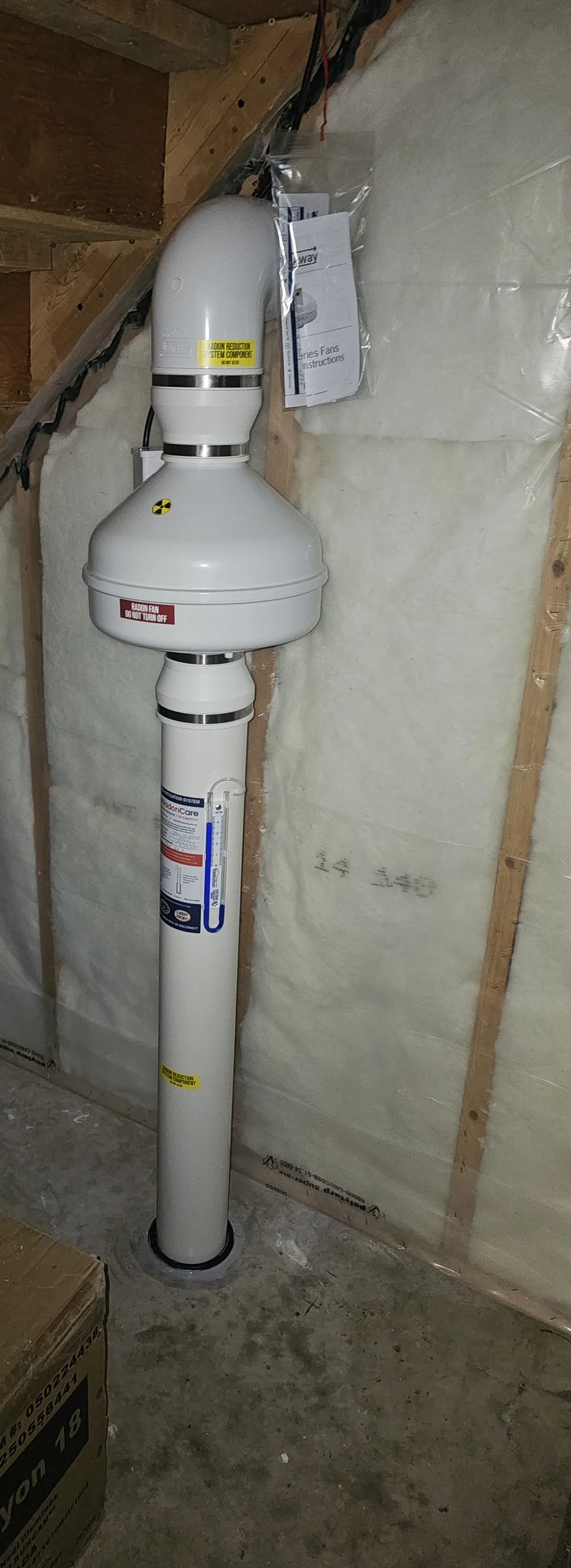 Radon Fan And Labelled Pipe In An Unfinished Space Under The Stairs In A St. Albert Basement