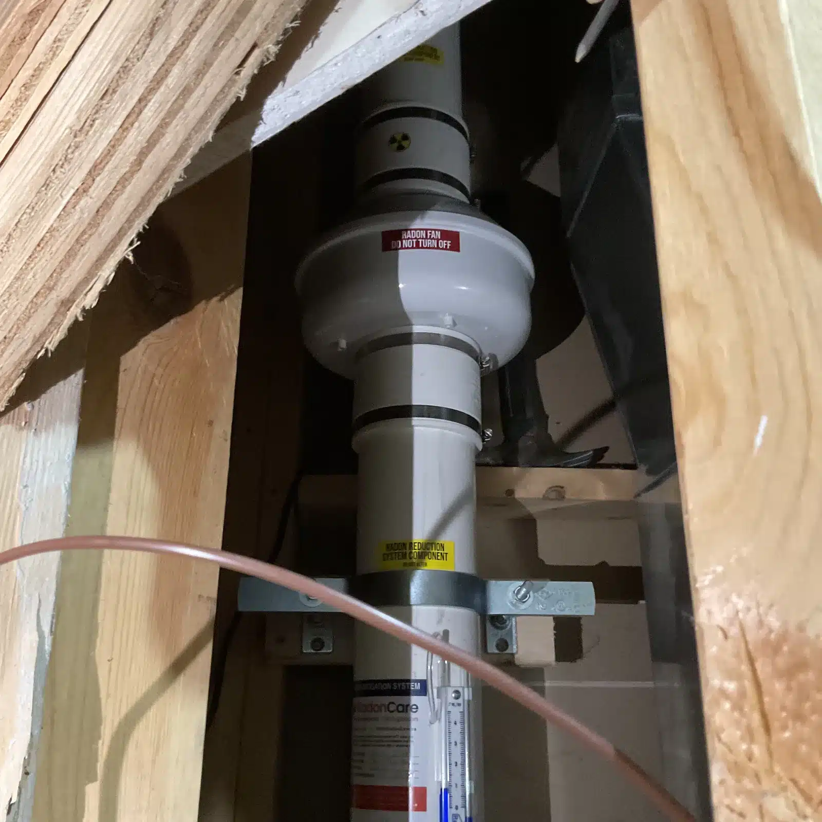 Radon Fan Tucked Into The Space Under The Stairs In A West Kelowna Basement