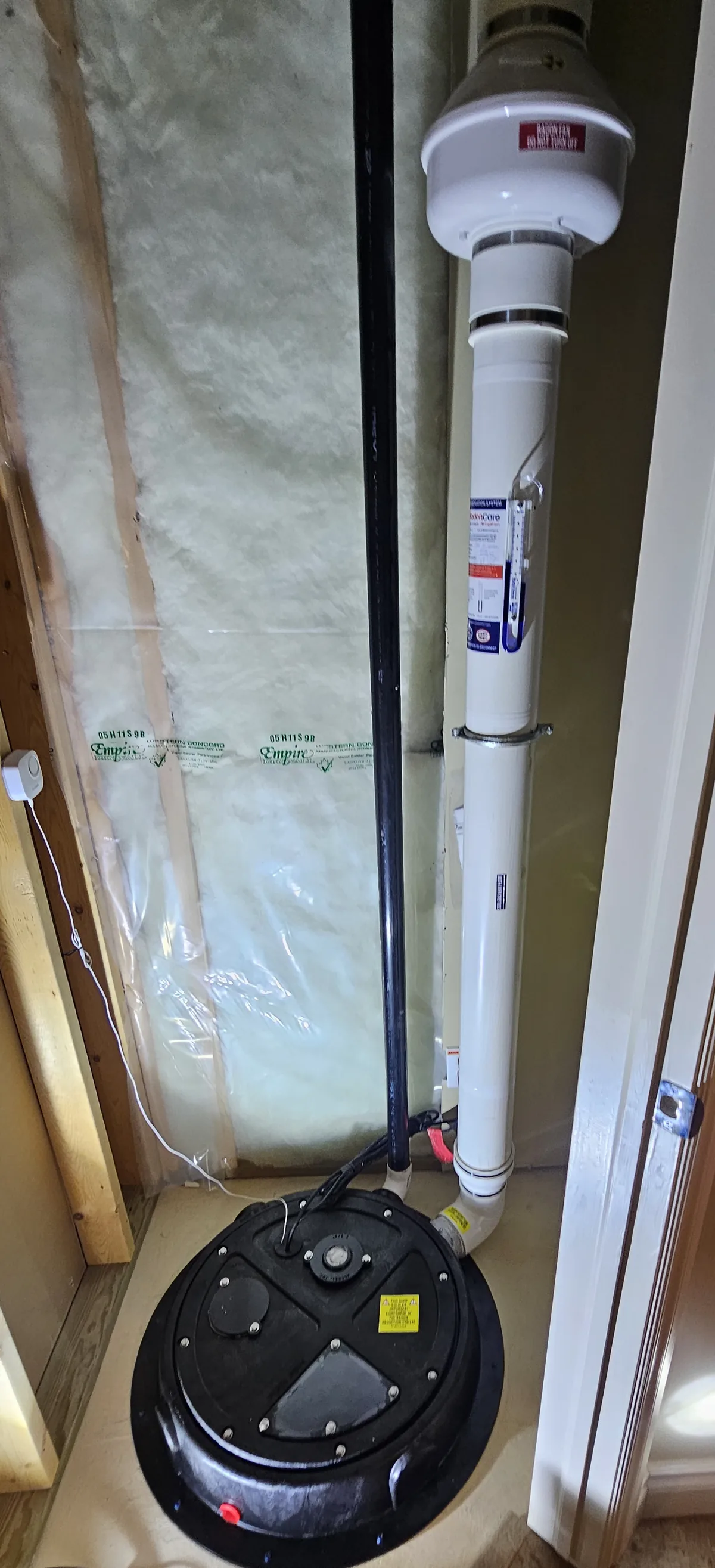 A Sealed Black Sump Lid In A Framed Closet With The Radon Pipe Rising To The Fan In A Sherwood Park-Area Home
