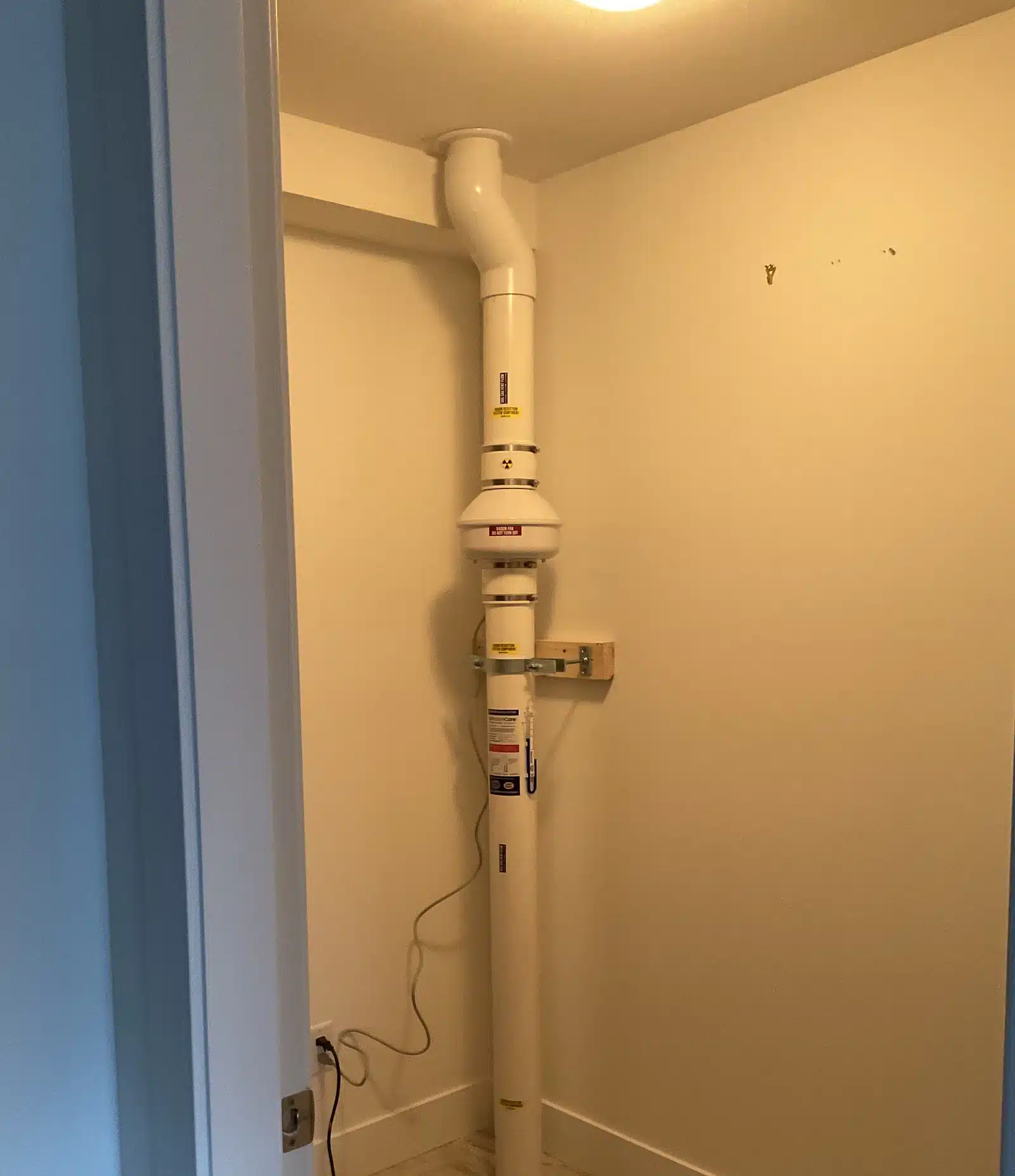 Radon Fan And Labelled Pipe In A Finished Closet In A West Kelowna Walkout Home