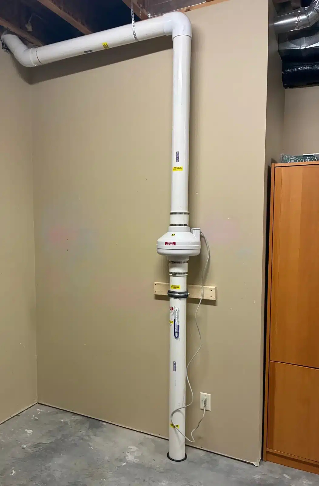 Radon Fan With The Vent Pipe Running Along A Basement Ceiling In Salmon Arm