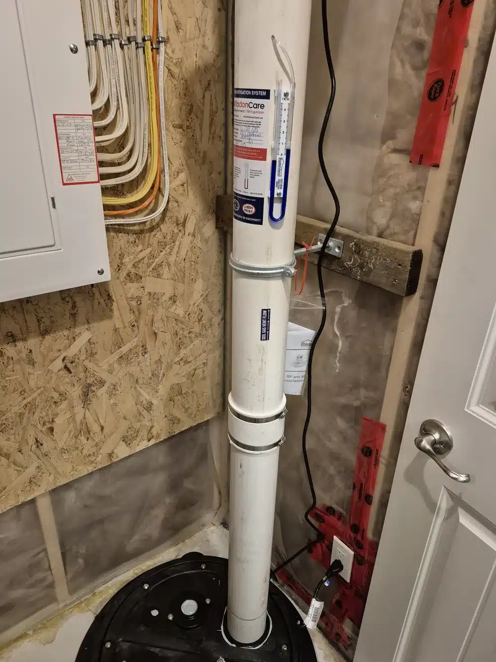 Radon Pipe And Pressure Gauge On A Sealed Sump Lid In A Home Near Red Deer